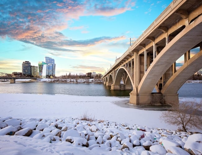 A bridge crossing a river over to Saskatoon, with ice and snow on the water